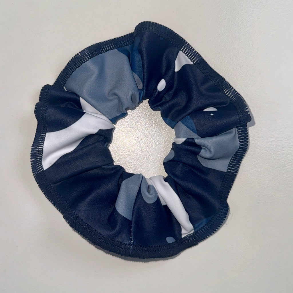 Navy blue, gray, and white scrunchie on a light gray background