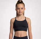 A young girl with a high ponytail wearing a black athletic sports bra and matching black bottoms, photographed against a clean light gray studio background.